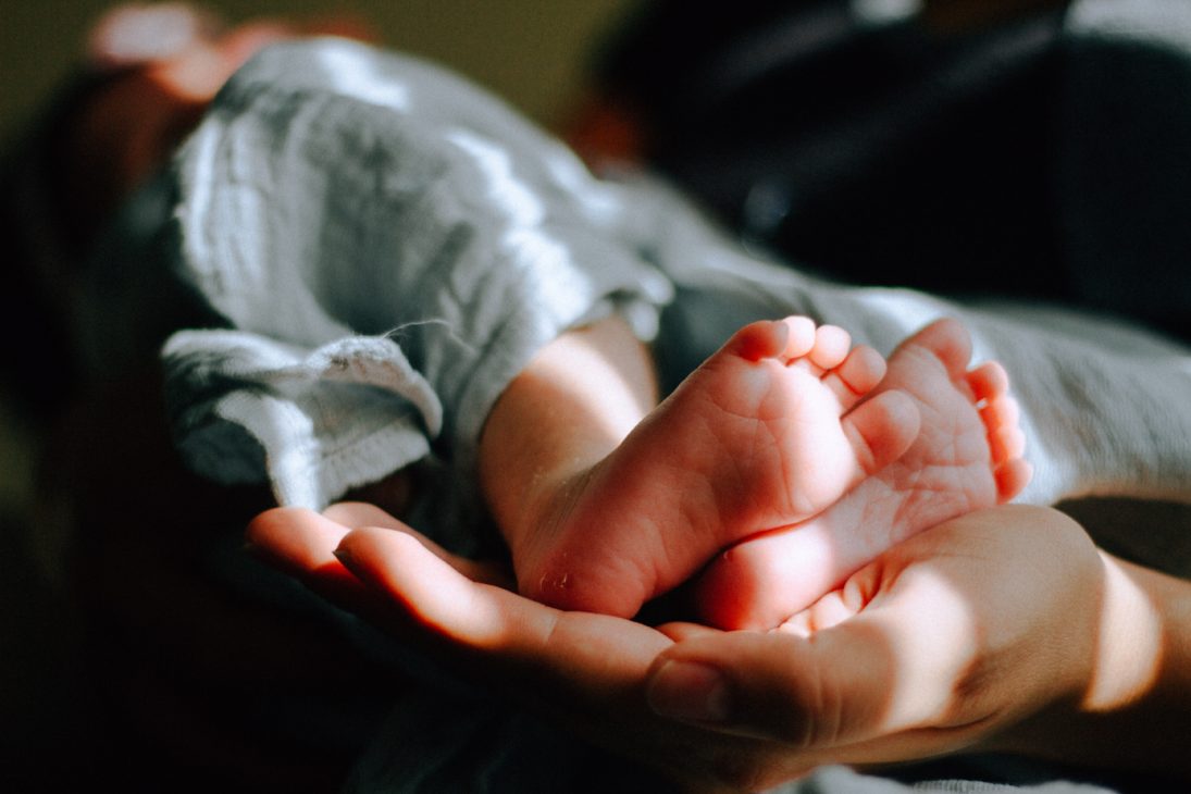 mothers hand holding baby feet