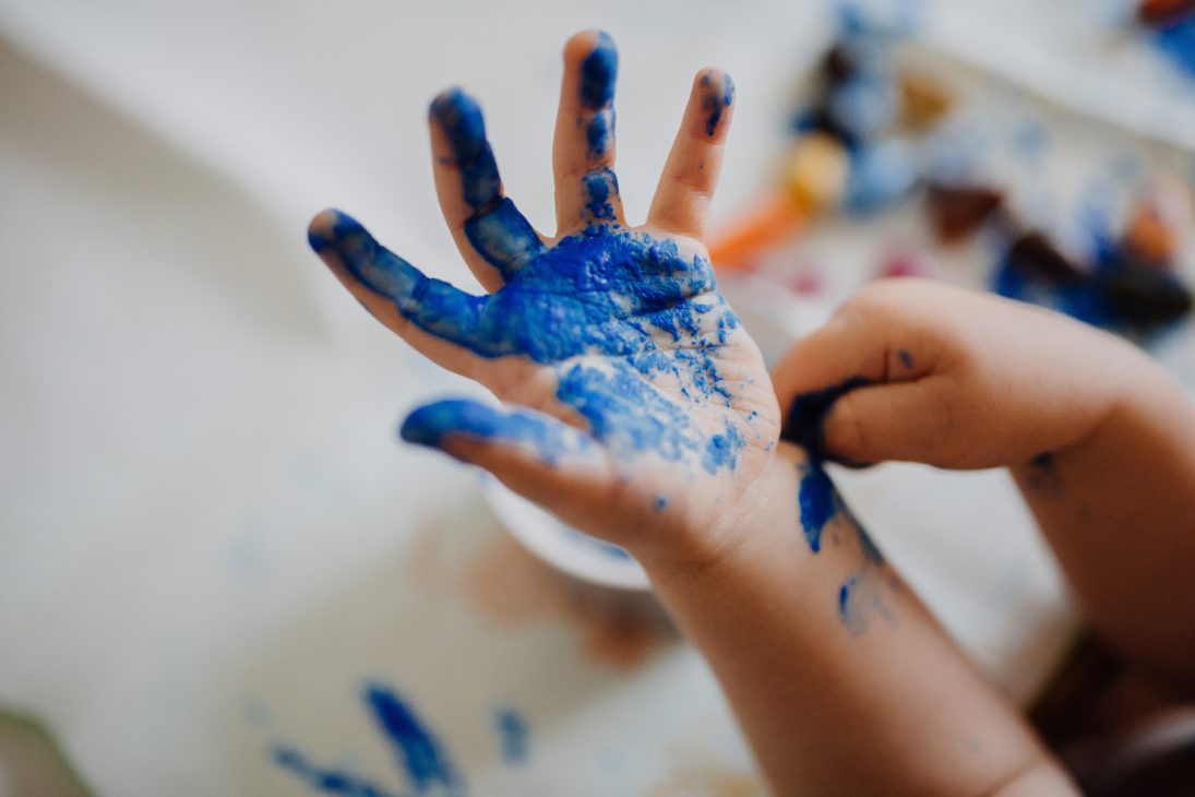 child's hand full of paint
